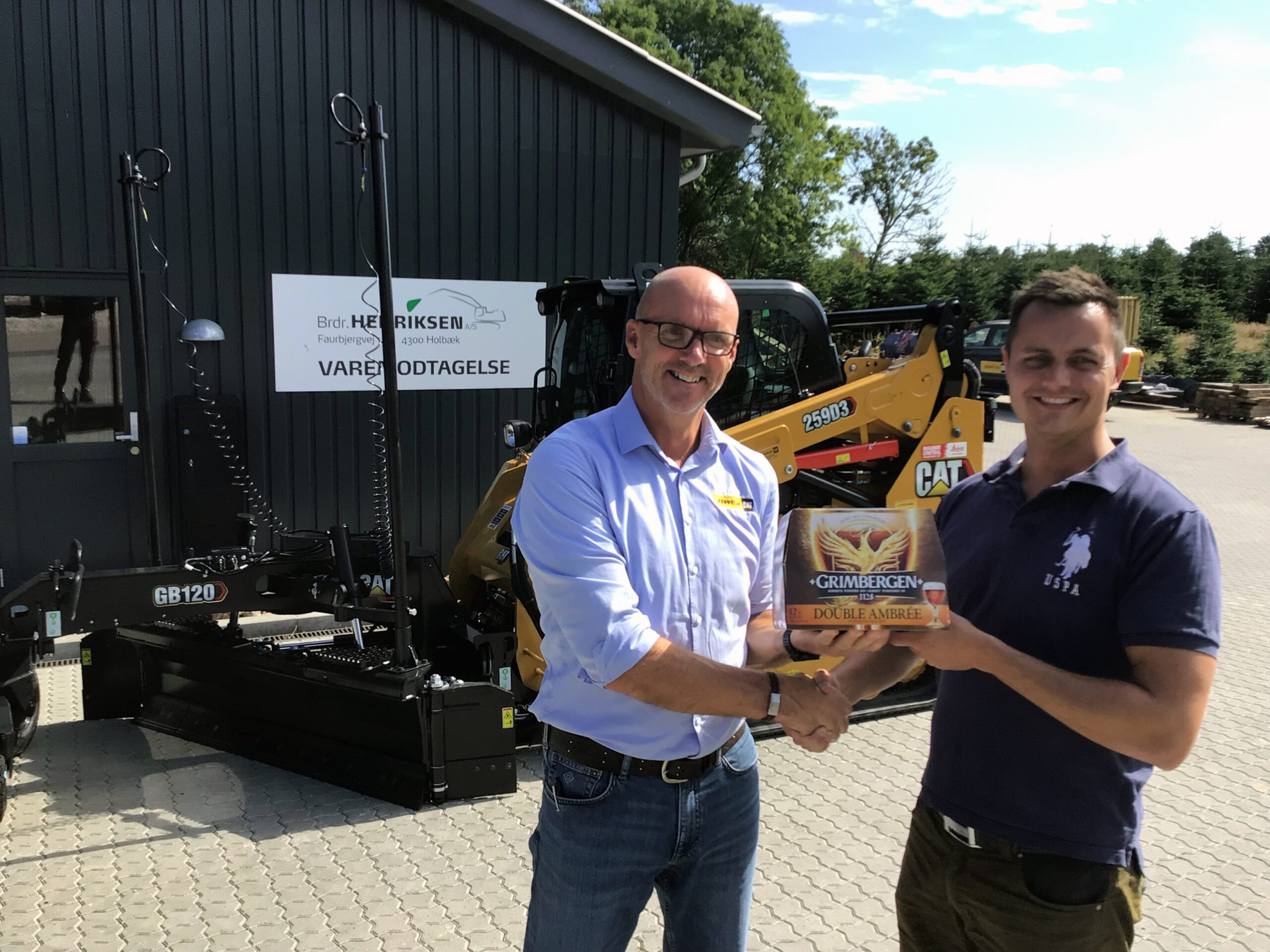 Distriktschef-John-Tops-tv-havde-taget-Grimbergen-oel-med-til-Kasper-Henriksen-for-at-markere-at-noget-af-det-medfoelgende-udstyr-netop-var-kommet-hjem-fra-Grimbergen-scaled