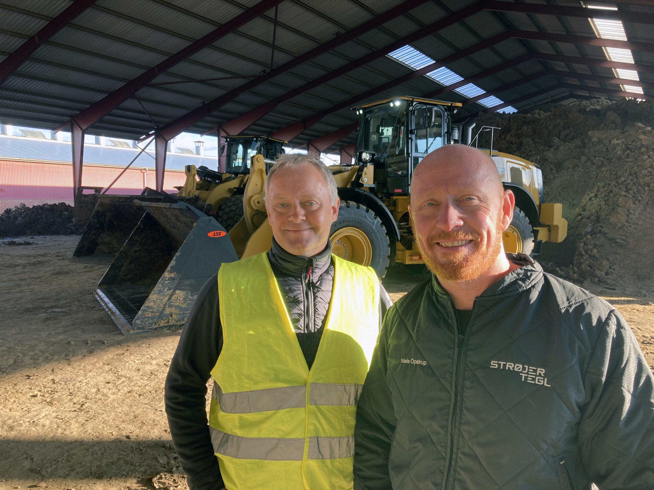 Distriktschef-Niels-Hansen-Zeppelin-tv-overdrager-de-to-nye-Cat-laessemaskiner-til-teknisk-chef-Niels-Opstrup-Stroejer-Tegl-scaled