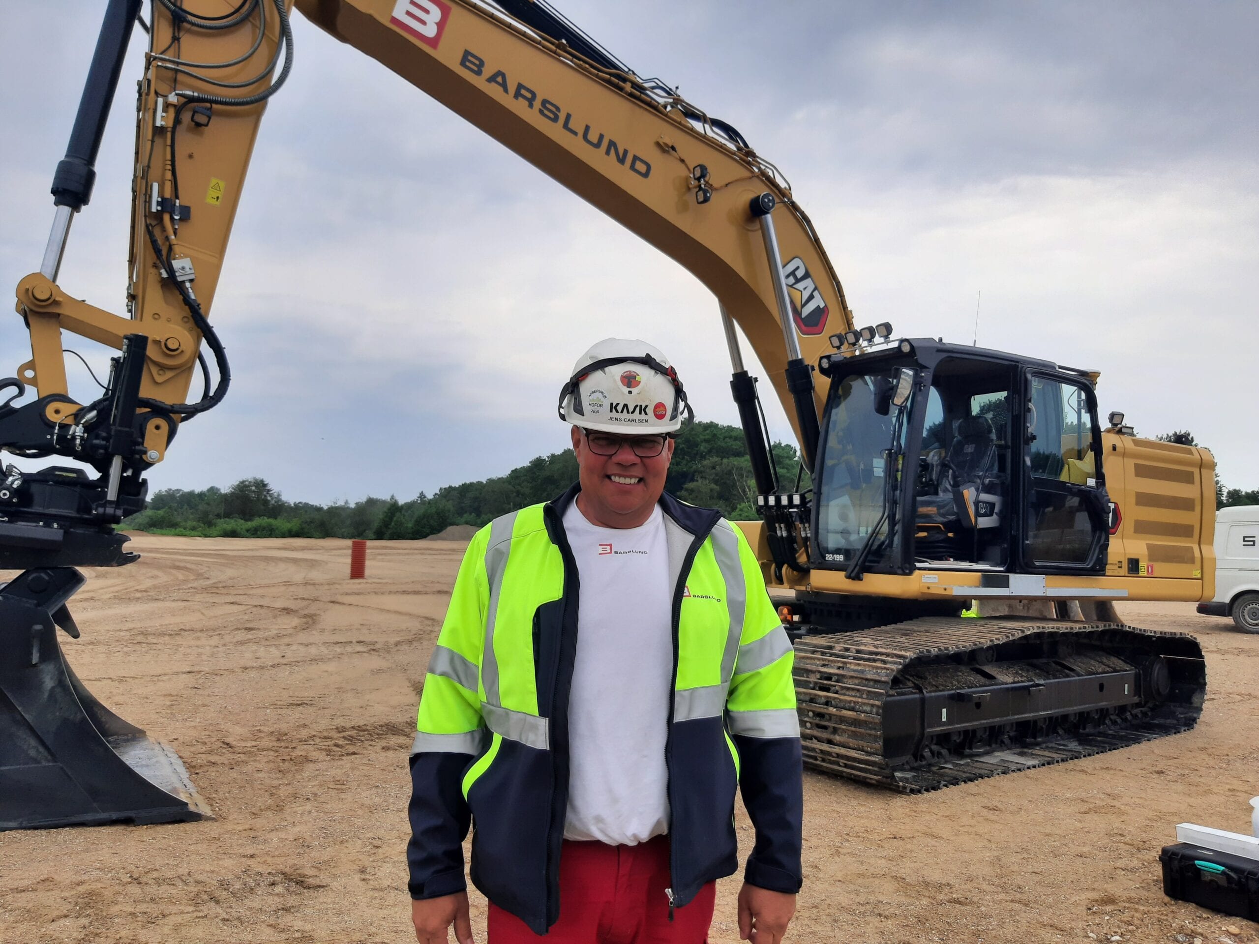 Maskinfoerer-Jens-Carlsen-foran-sine-nye-Cat-330-gravemaskine-scaled