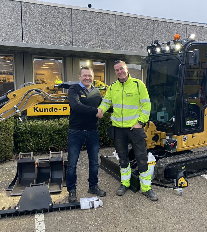 Salgskonsulent Kenneth Green Christensen (tv) giver hånd til Dannie Schmidt fra Hinbjerg Entreprise. Virksomheden har netop købt vores meget populære Cat 301.8 mini gravemaskine.